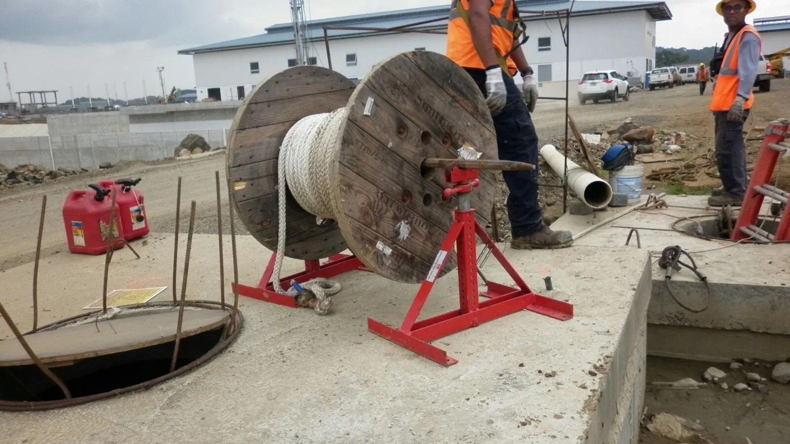 Personal trabajando junto a un carrete de cable durante la instalación eléctrica para la operación de una compuerta del sector Pacífico
