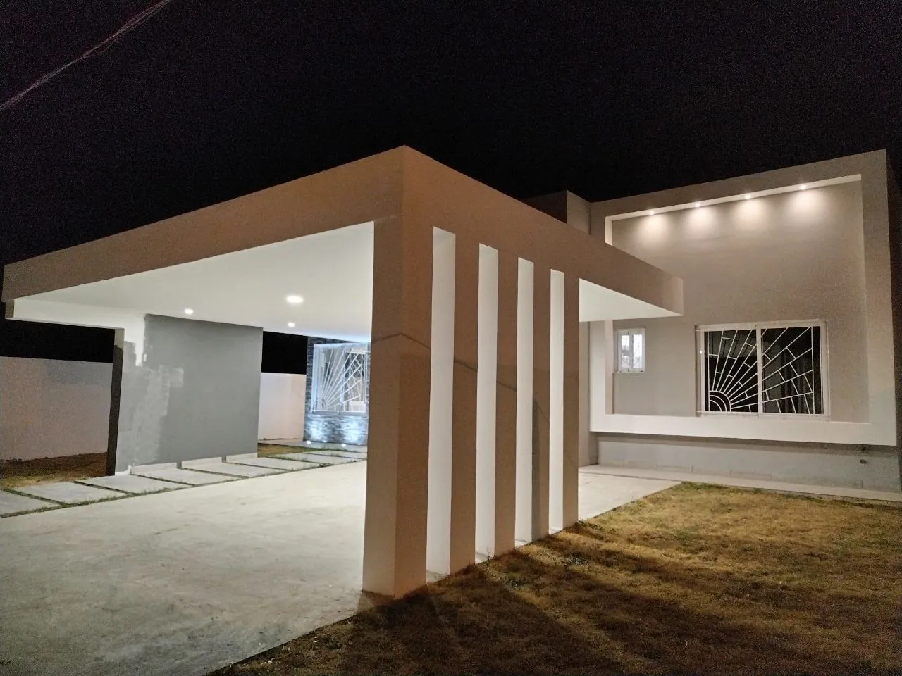 Fachada nocturna de una vivienda unifamiliar terminada en Coronado